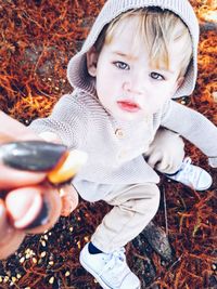 High angle view of cute baby sitting on field