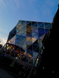 Low angle view of glass building against blue sky