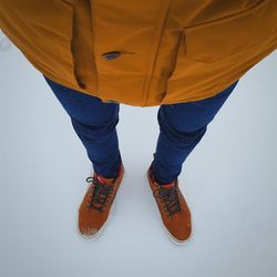 Low section of man standing against white background