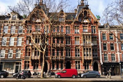 Cars on road by buildings in city