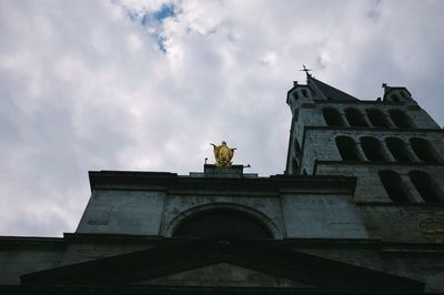 Low angle view of building against cloudy sky