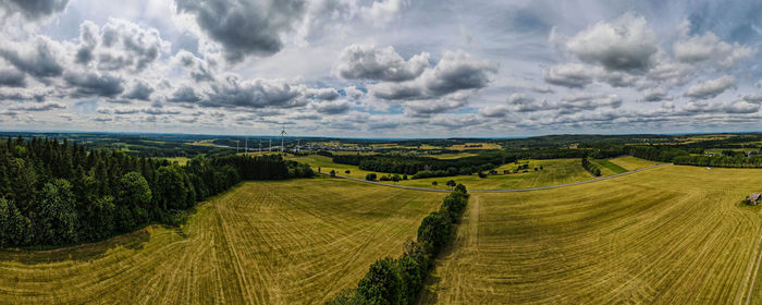 Panoramic view of agricultural field against sky