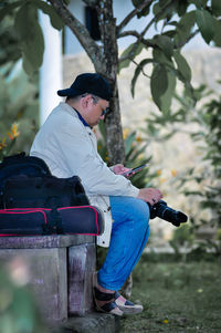 Side view of man sitting on car