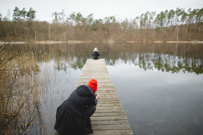 Rear view of person on lake against sky