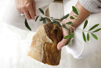 Close-up of man holding plant and bread