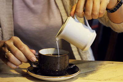 Midsection of coffee cup on table