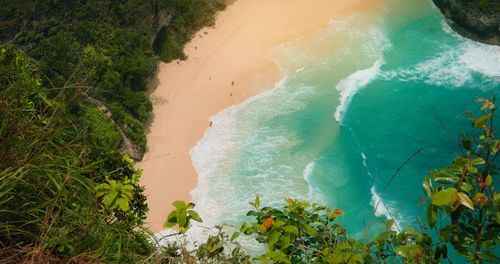 Ocean on golden sandy kelingking beach at sunset in bali nusa penida indonesia. tropical landscape.