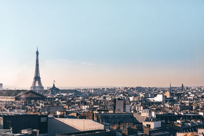 Aerial view of buildings in city against sky