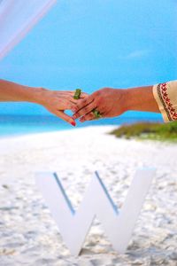 Woman hand holding umbrella on beach