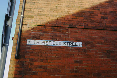 Low angle view of text on brick wall
