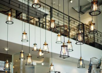 Low angle view of illuminated pendant light hanging at home