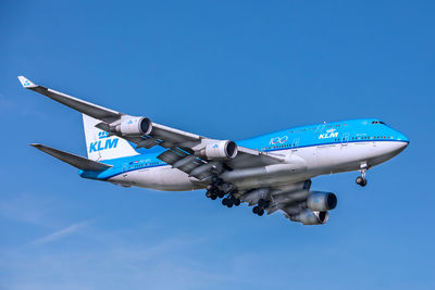 Low angle view of airplane against clear blue sky