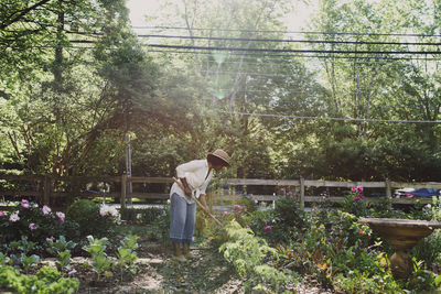 Woman working in garden during sunny day