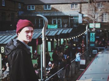 Portrait of man wearing knit hat while standing on street in city