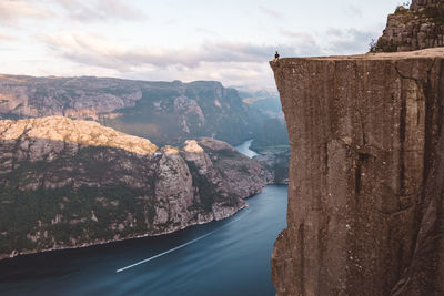 Man sitting at edge of cliff at preikestolen, norway