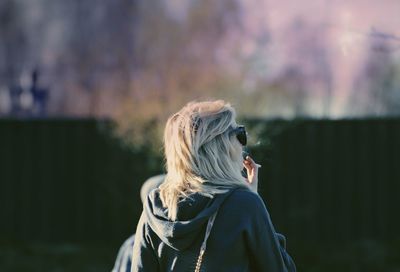 Rear view of woman standing against blurred background