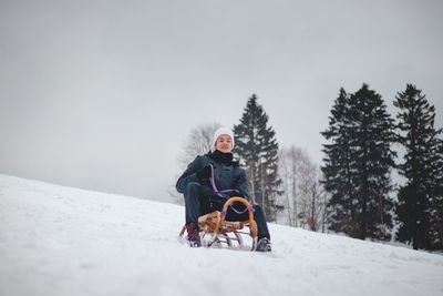 Teenager caught riding on a wooden sledge trying to adjust his direction with his hand 