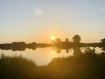 Scenic view of lake against sky during sunset