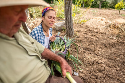 Happy man holding food while standing by plants in farm