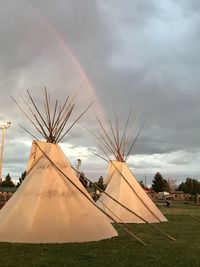 Tents on field against cloudy sky