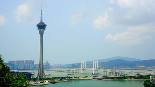 View of suspension bridge over river against cloudy sky