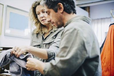 Low angle view of mature colleagues examining fabric at warehouse