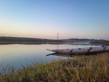 Traditional wood boat at calm lake with dramatic sunrise colorful sky reflection at morning