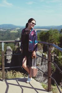 Full length of young woman standing at observation point