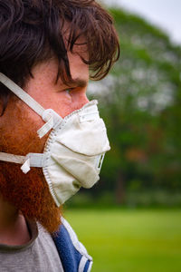 Close-up of man wearing flu mask outdoors