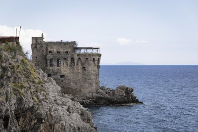 Building by sea against sky