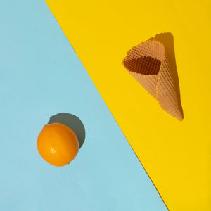 Lemon and ice cream cone on yellow and blue background. minimal summer food concept. flat lay.