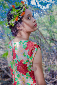 Close-up of young woman standing against tree