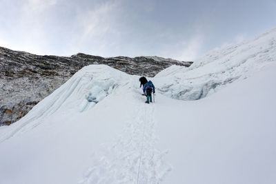 Tourists on snow covered mountain