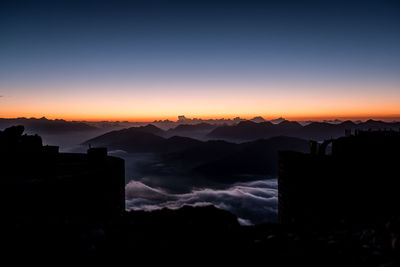 Silhouette buildings against sky during sunset