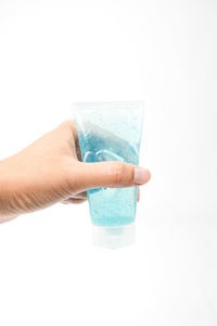 Midsection of person holding ice cream against white background