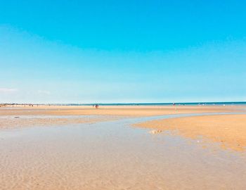 Scenic view of beach against blue sky