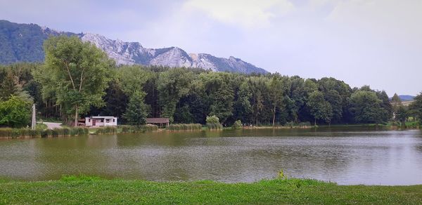 Scenic view of lake by trees against sky