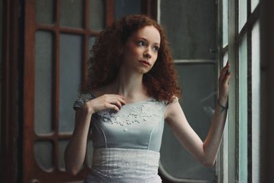 Young woman standing against wall