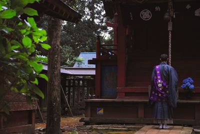 Rear view of woman standing by tree