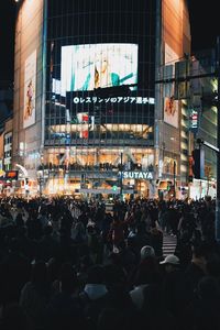 People walking on street against buildings in city