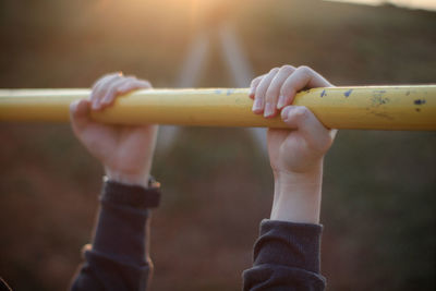 Cropped hands of man holding rod at park