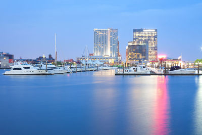 Boats moored at harbor against buildings in city 