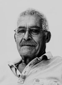 Portrait of man wearing eyeglasses against white background