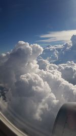 Airplane wing against cloudy sky