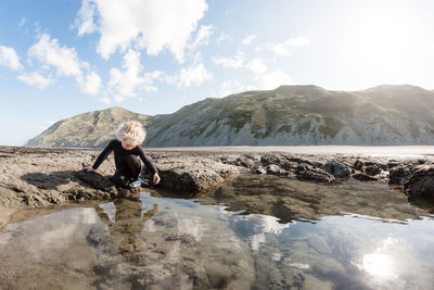 Young boy exploring rock pools on a sunny day