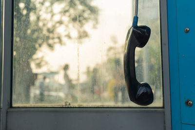 Telephone receiver hanging against window