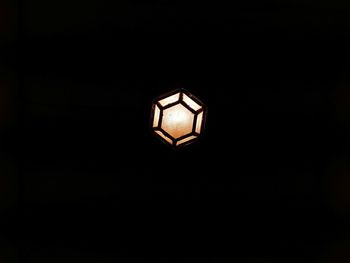Low angle view of illuminated light bulb in the dark