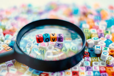 Close-up of love text on magnifying glass