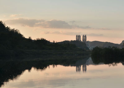 Reflection of building in lake during sunset