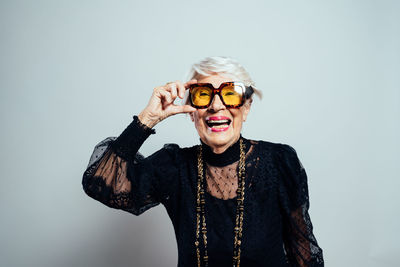 Young woman wearing sunglasses against white background